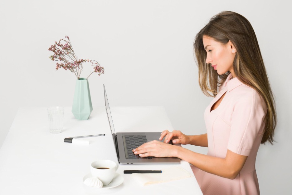 Smartly dressed investor checking local real estate markets on her laptop.