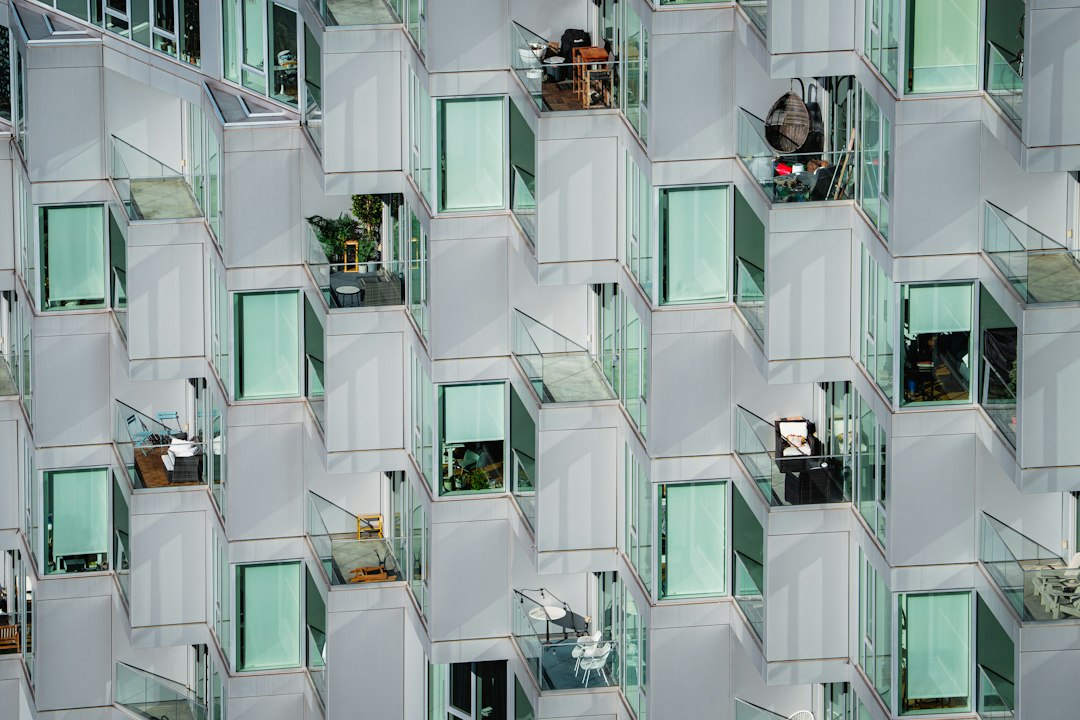 Modern apartment tower facade with glass balconies (illustrative stock photo)