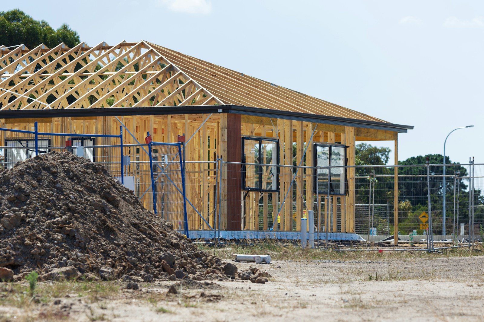Illustrative stock photograph of a house under construction with exposed roof trusses.