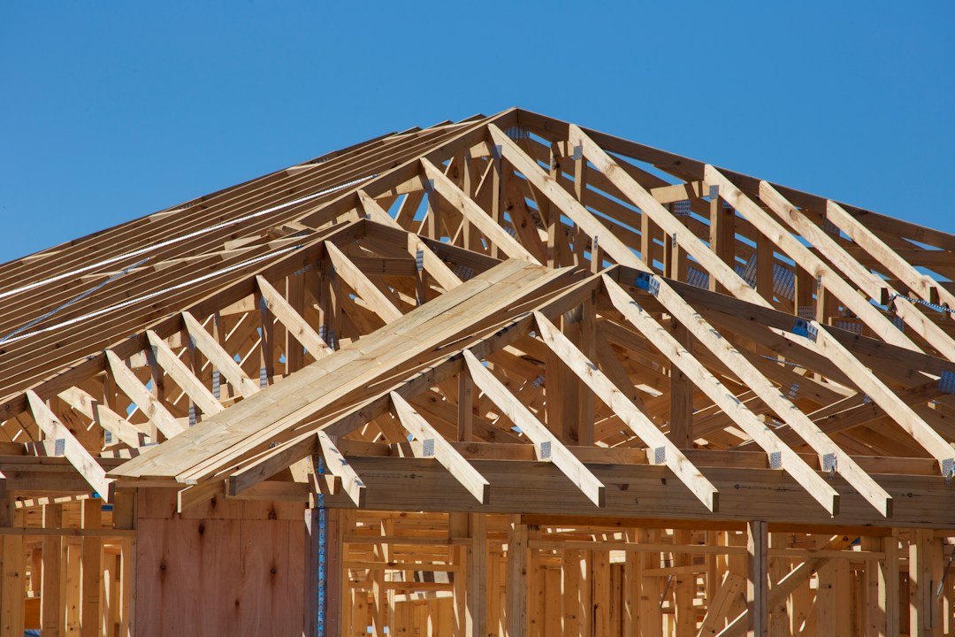 A new home under construction with timber framing and roof trusses, illustrative stock photo