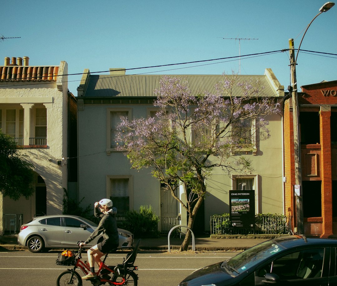 Person cycling past houses on a residential street