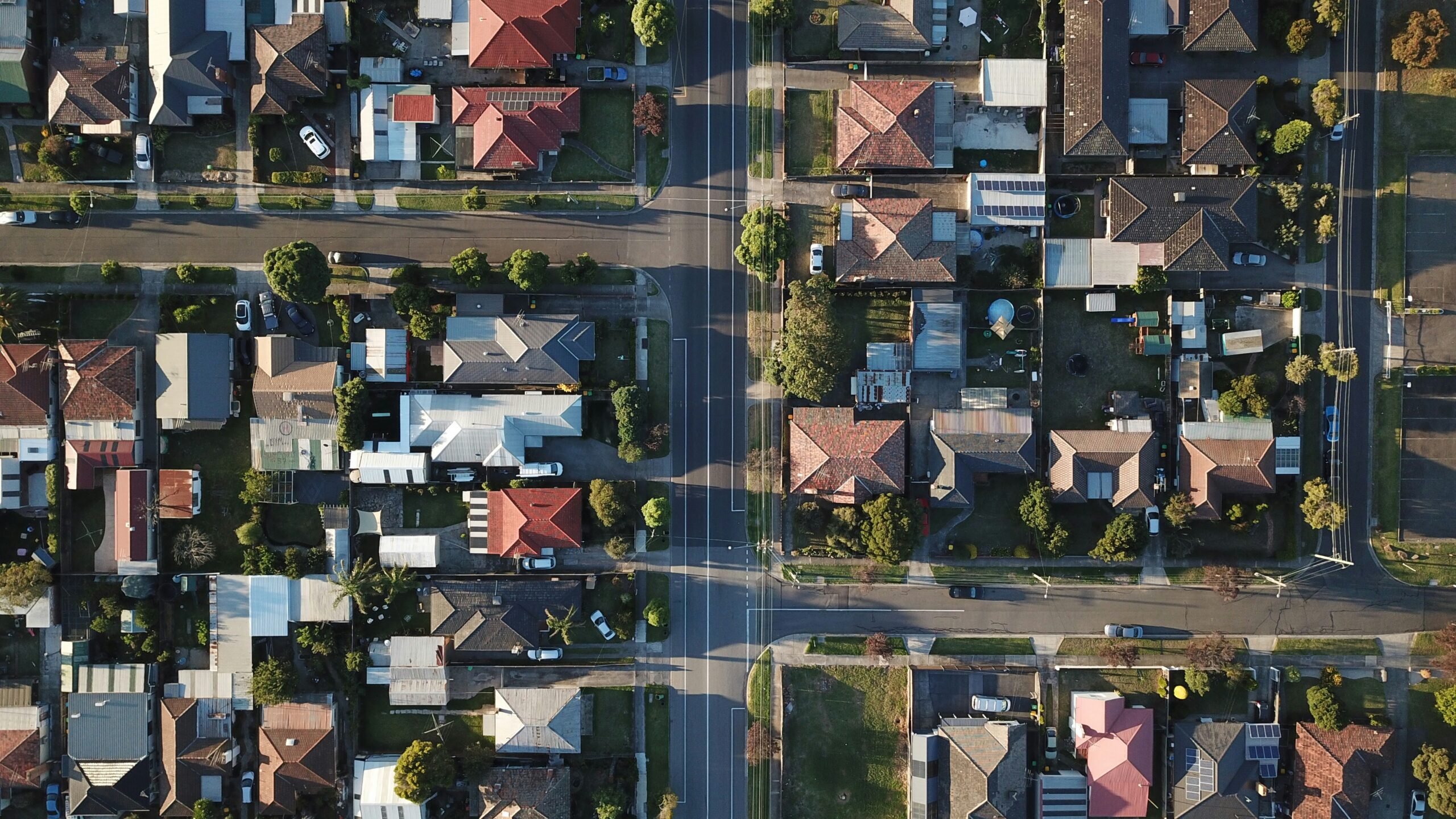 Rows of houses along suburban streets photographed from above in late afternoon light