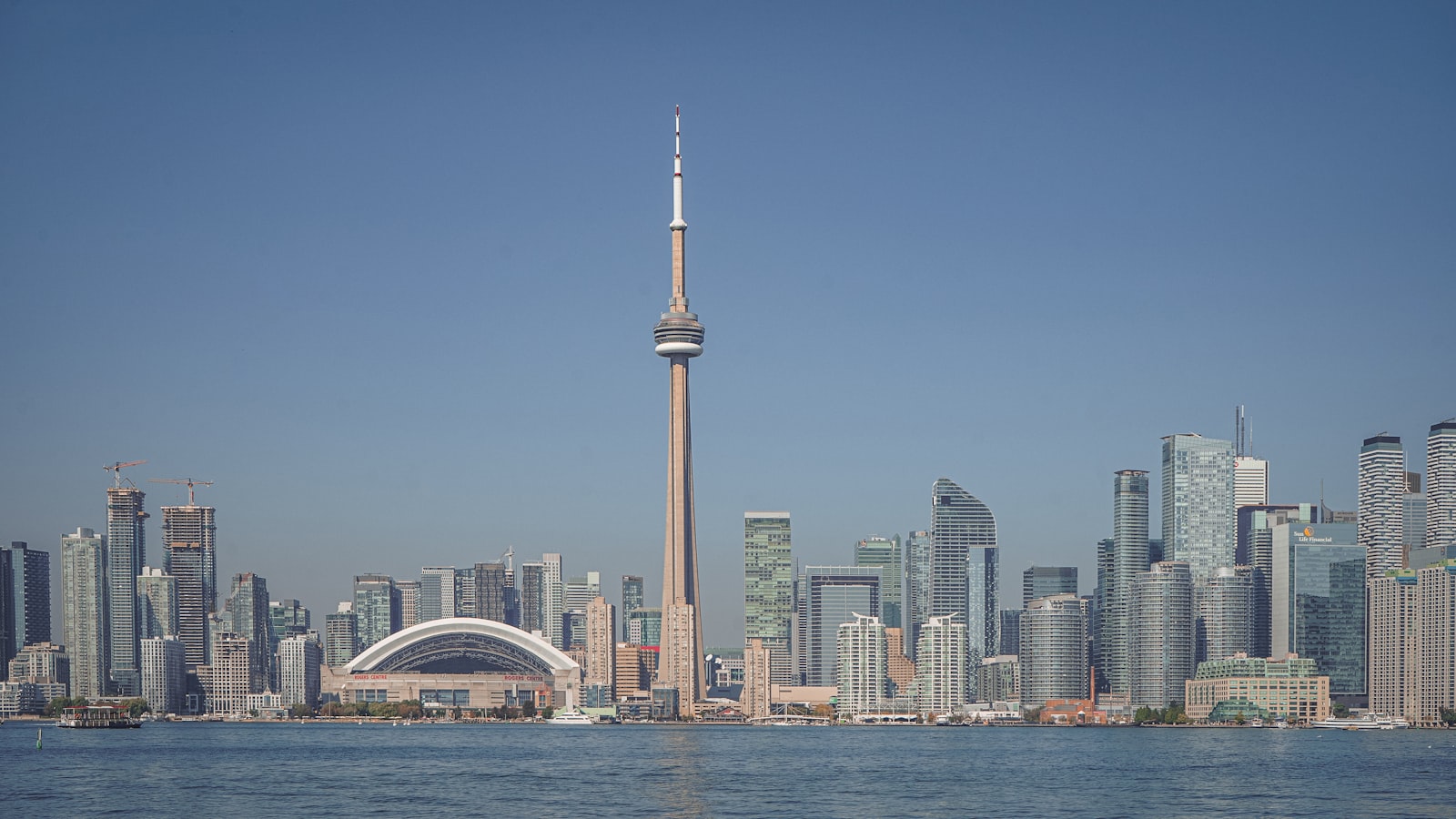 The Toronto waterfront skyline seen from Lake Ontario, with the CN Tower at centre and construction cranes at left