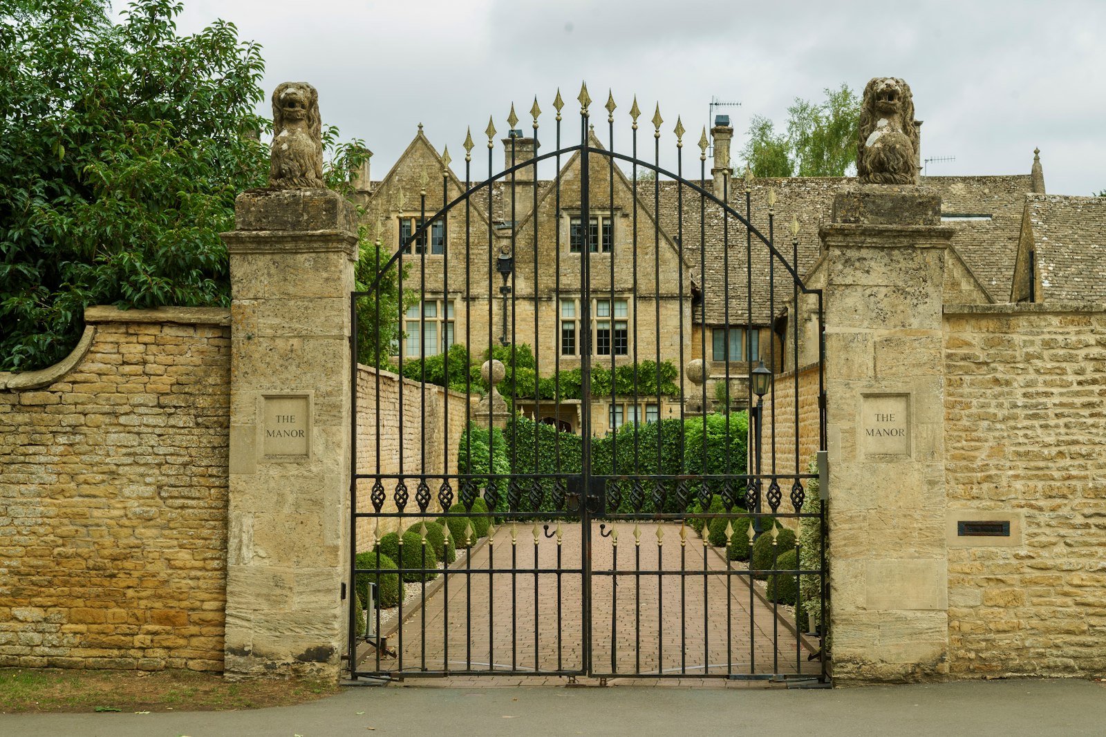 Wrought-iron gates in front of a stone manor house, file photo, not a listed property
