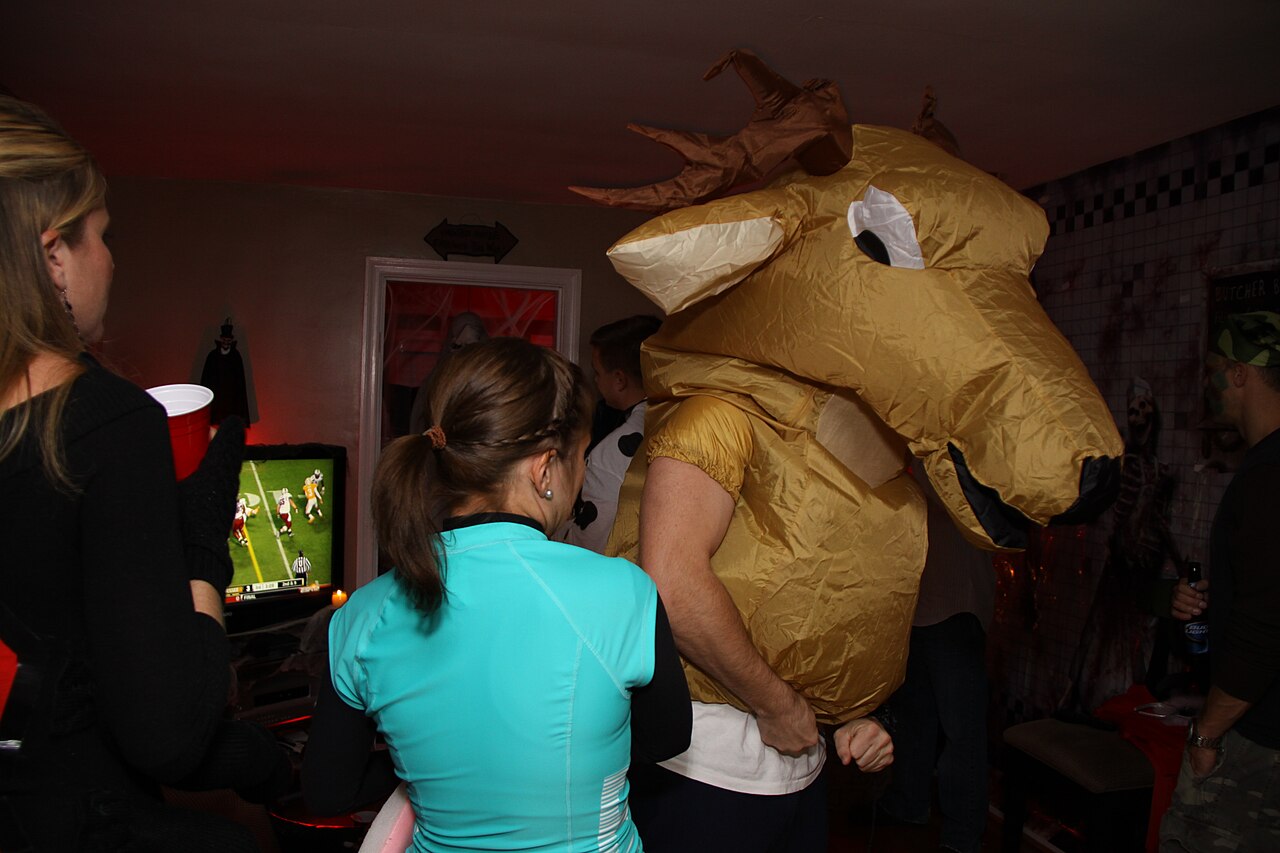 Person wearing a large gold inflatable animal costume at a party