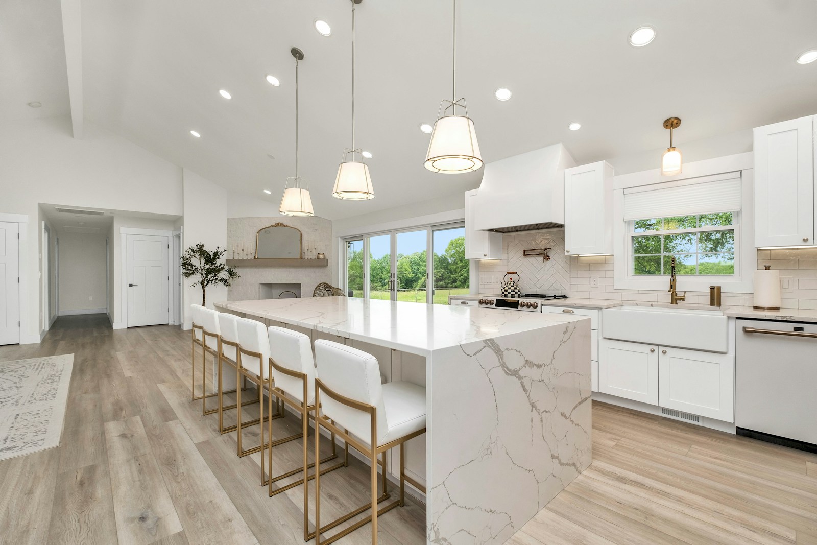 A kitchen with a marble island and white cabinets