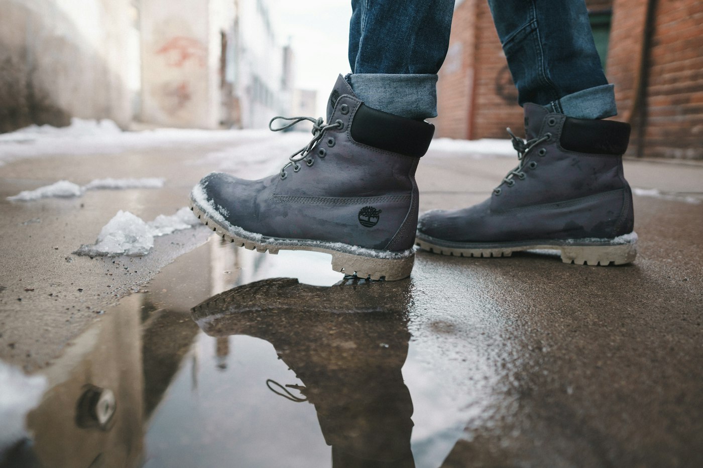 Grey lace-up winter boots in slush on a city street