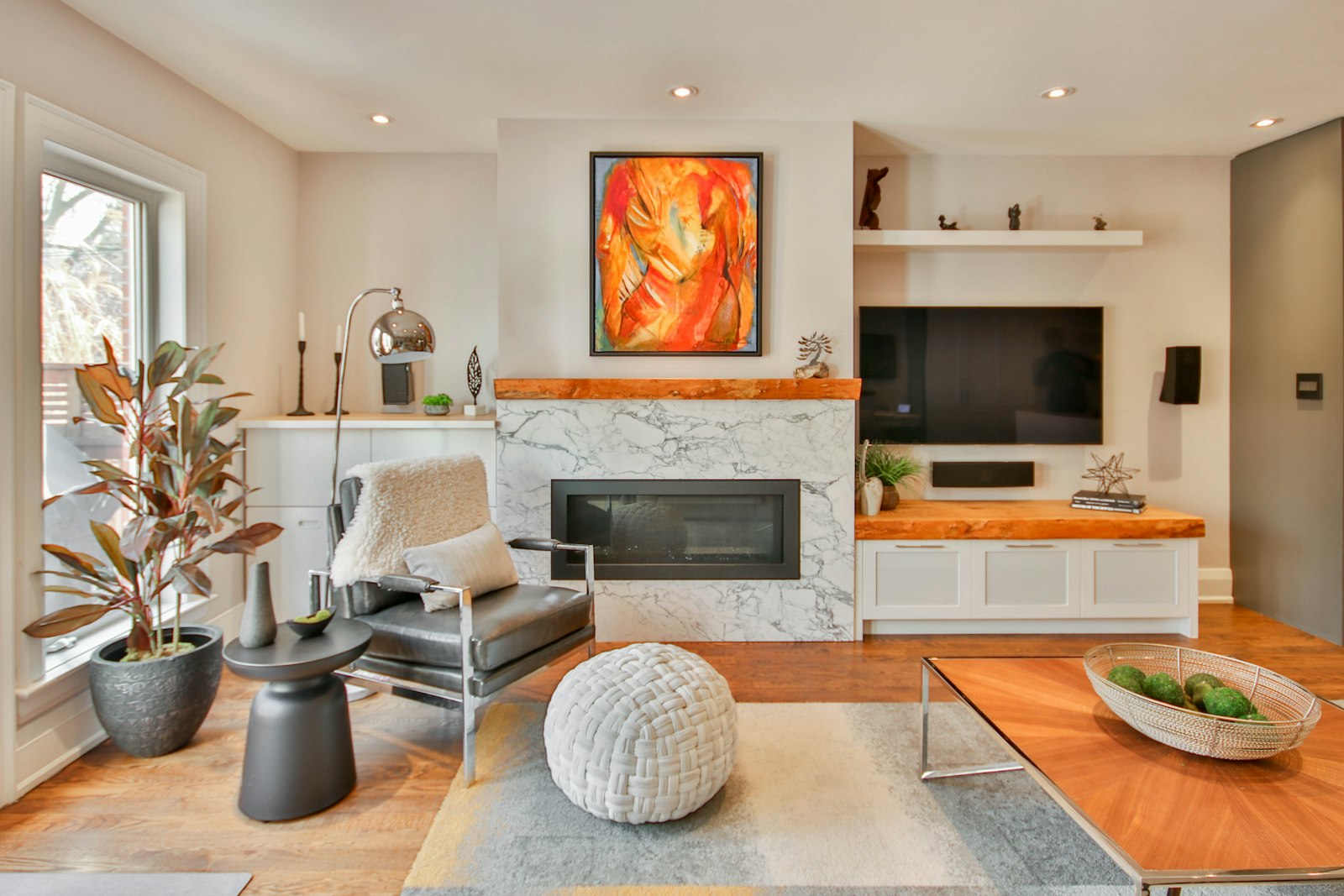 Living room with a painting above the fireplace and a wall-mounted TV