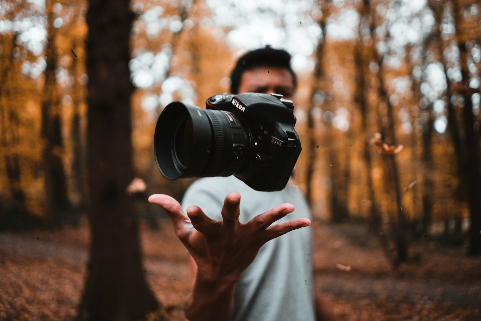 Photographer holding a mirrorless camera with a zoom lens outdoors