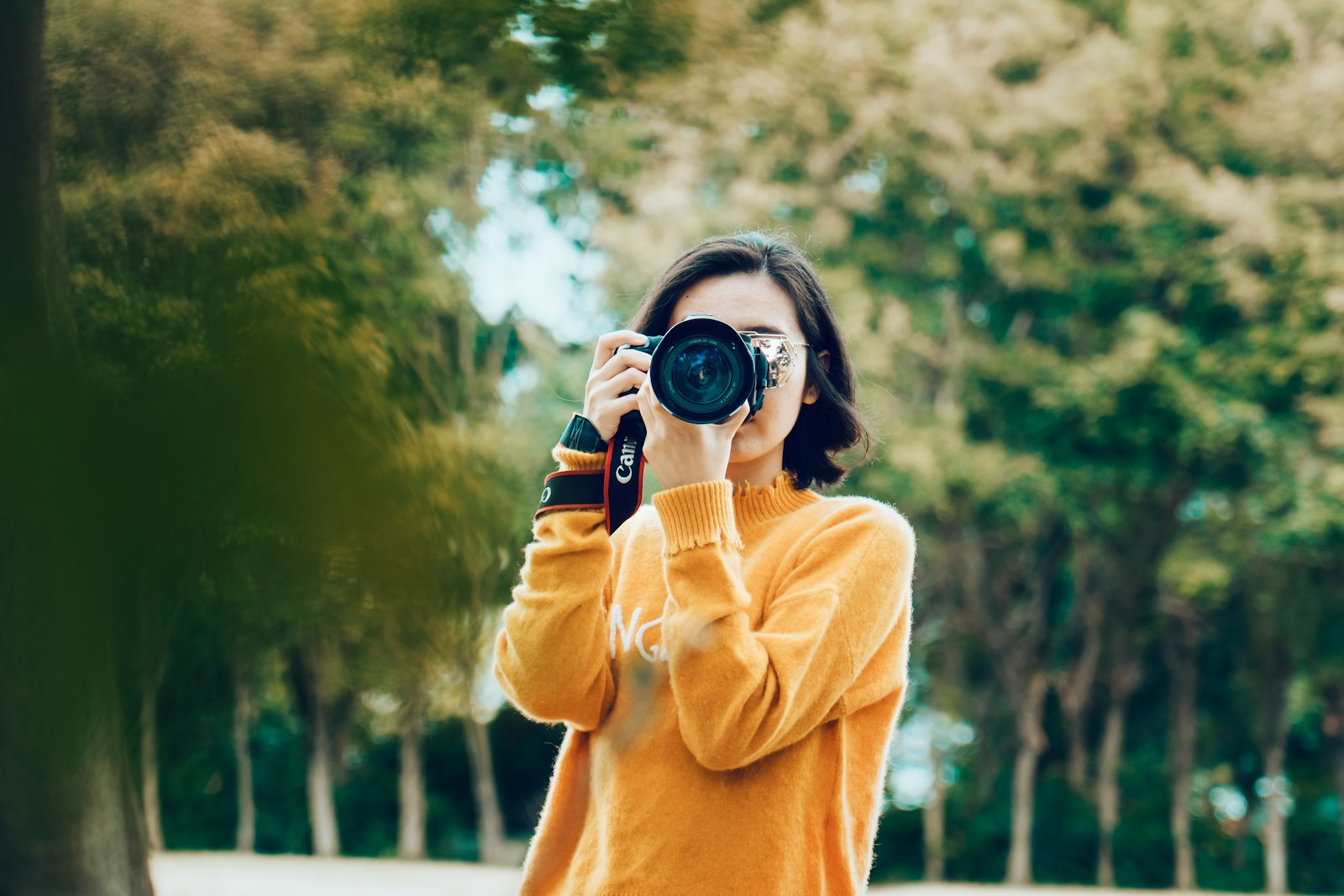 Person holding an interchangeable-lens camera at eye level