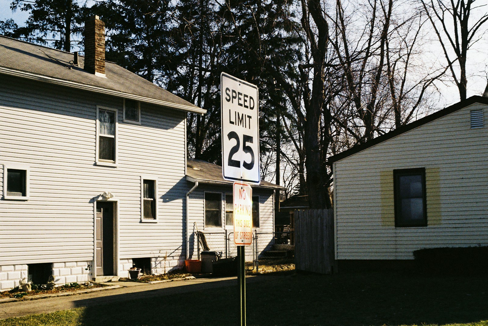 A street sign in front of a white house