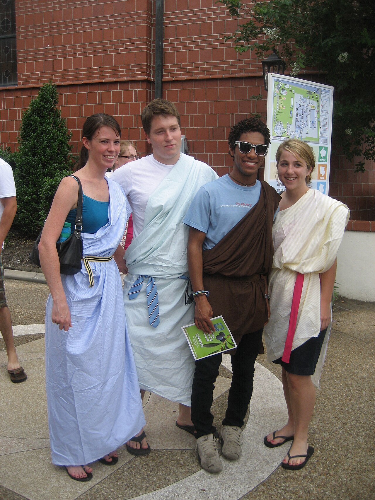 Four friends wearing toga costumes in white, blue and brown