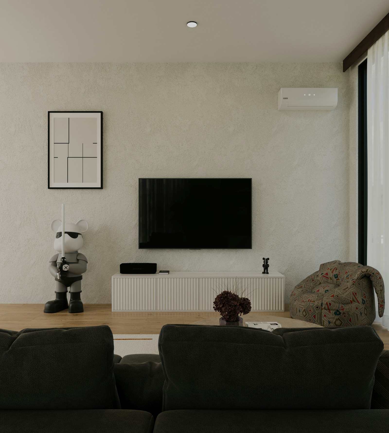 Wall-mounted TV beside a framed print in a living room, seen from a sofa