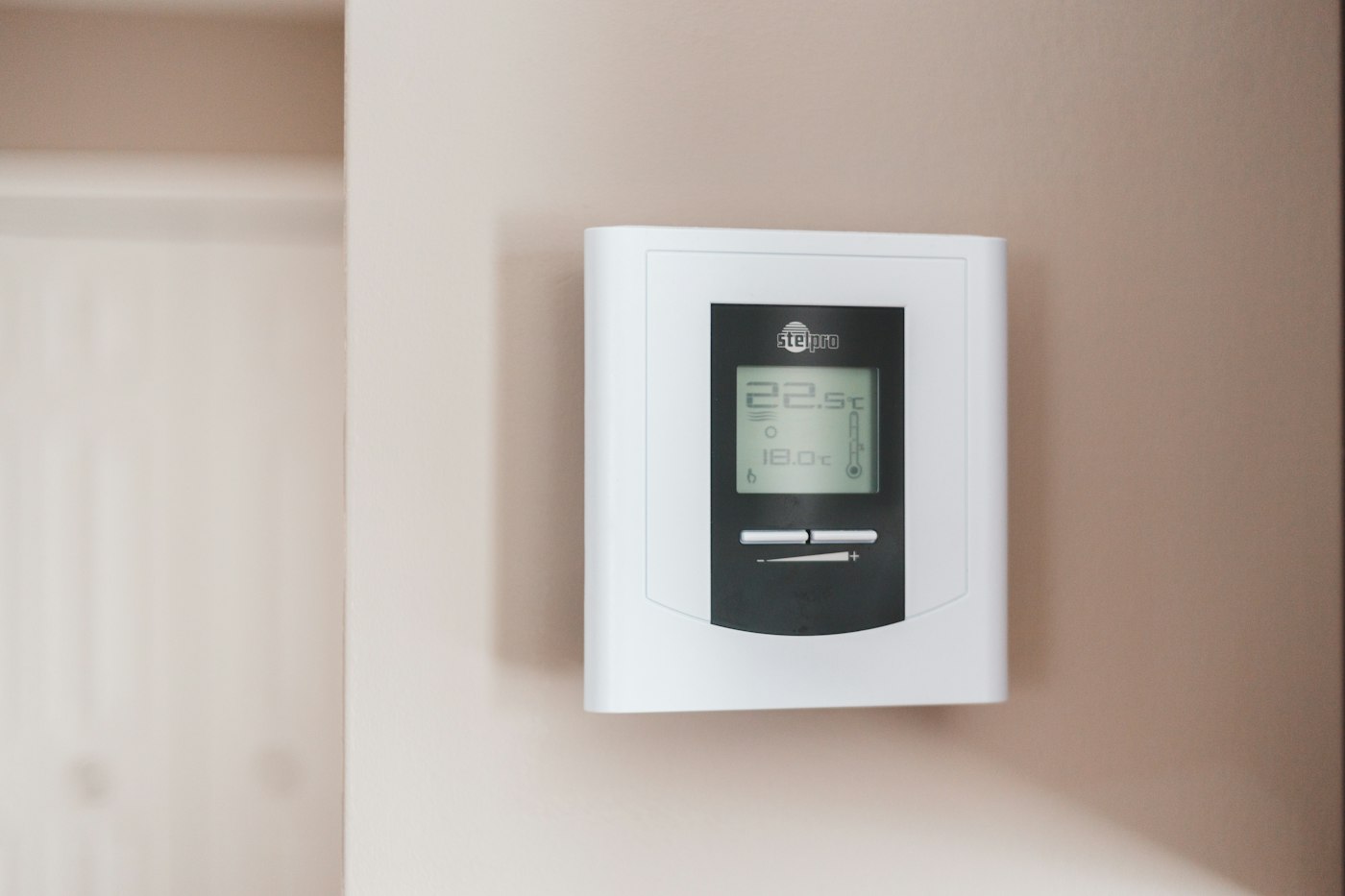 A white and grey wall thermostat showing 19.5 degrees