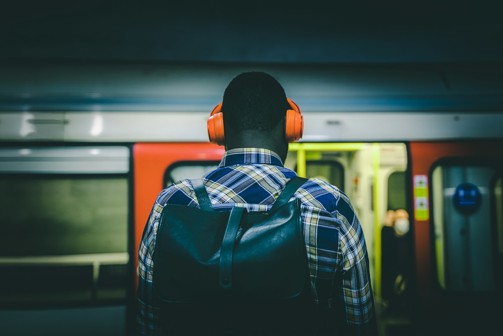 Commuter wearing headphones on a subway platform