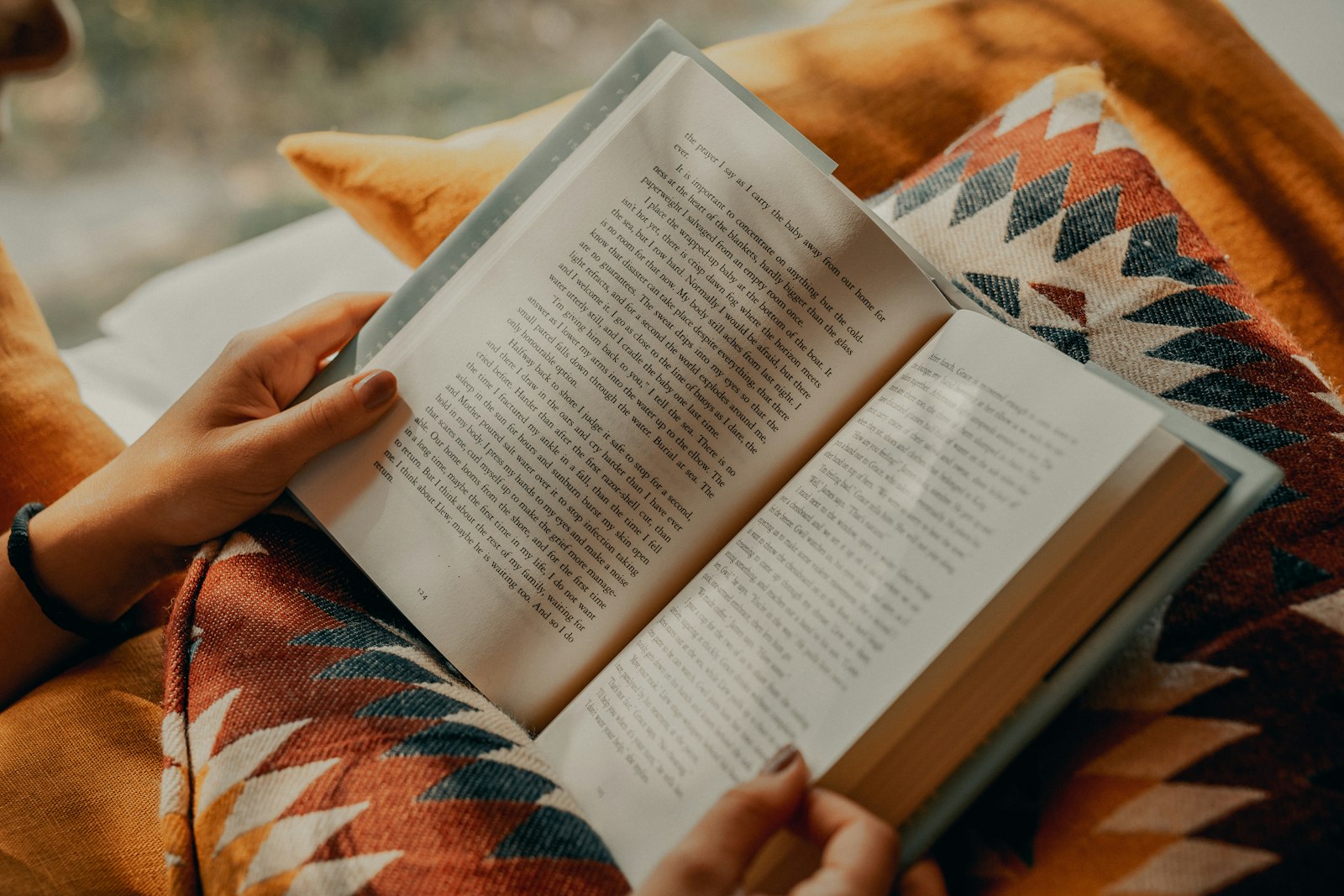 Person reading a book on a couch, a quiet moment for a new mom