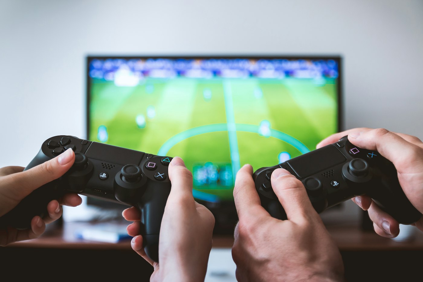 Hands holding video game controllers during a gaming session