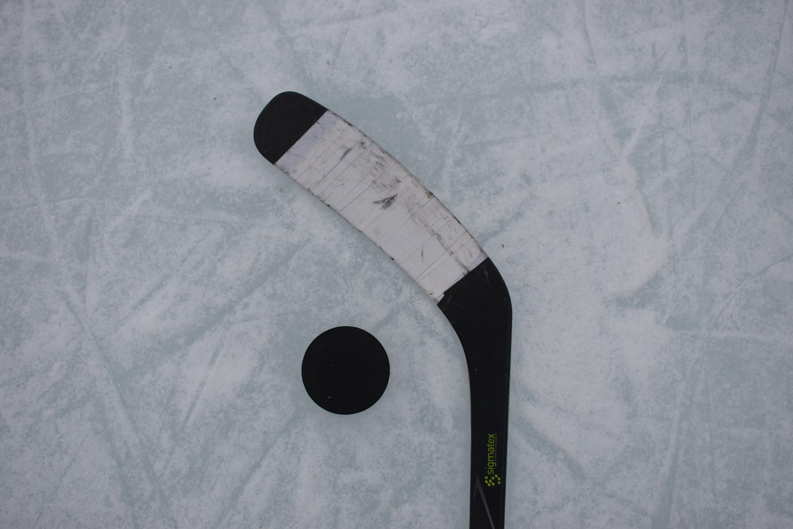 Hockey stick and puck resting on the ice