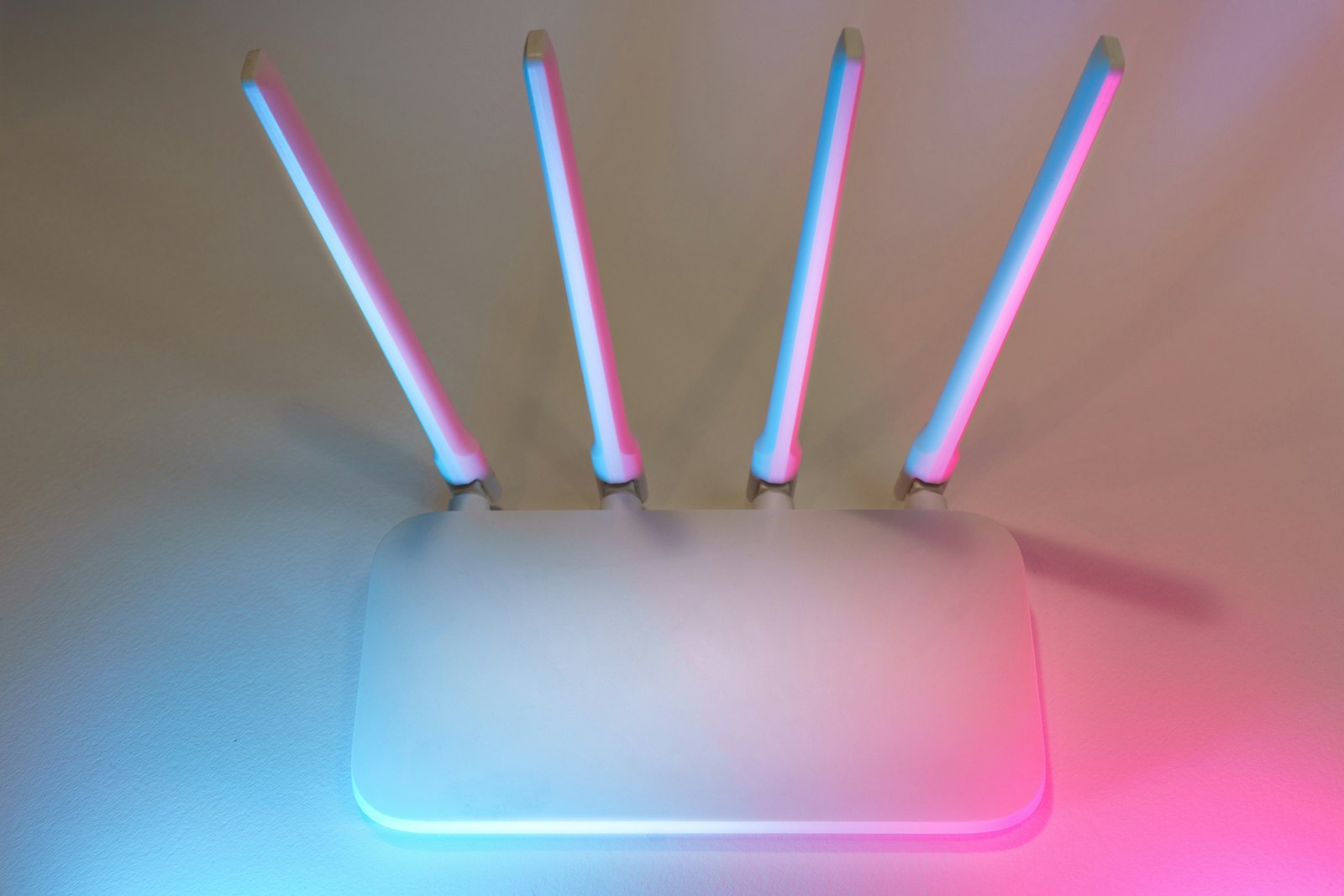 A white home Wi-Fi router with antennas on a shelf