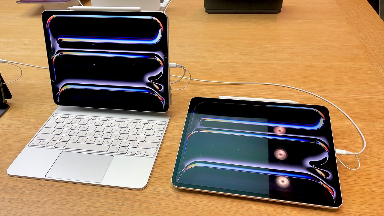 iPad Pro with Magic Keyboard and a second iPad Pro with Apple Pencil on a display table