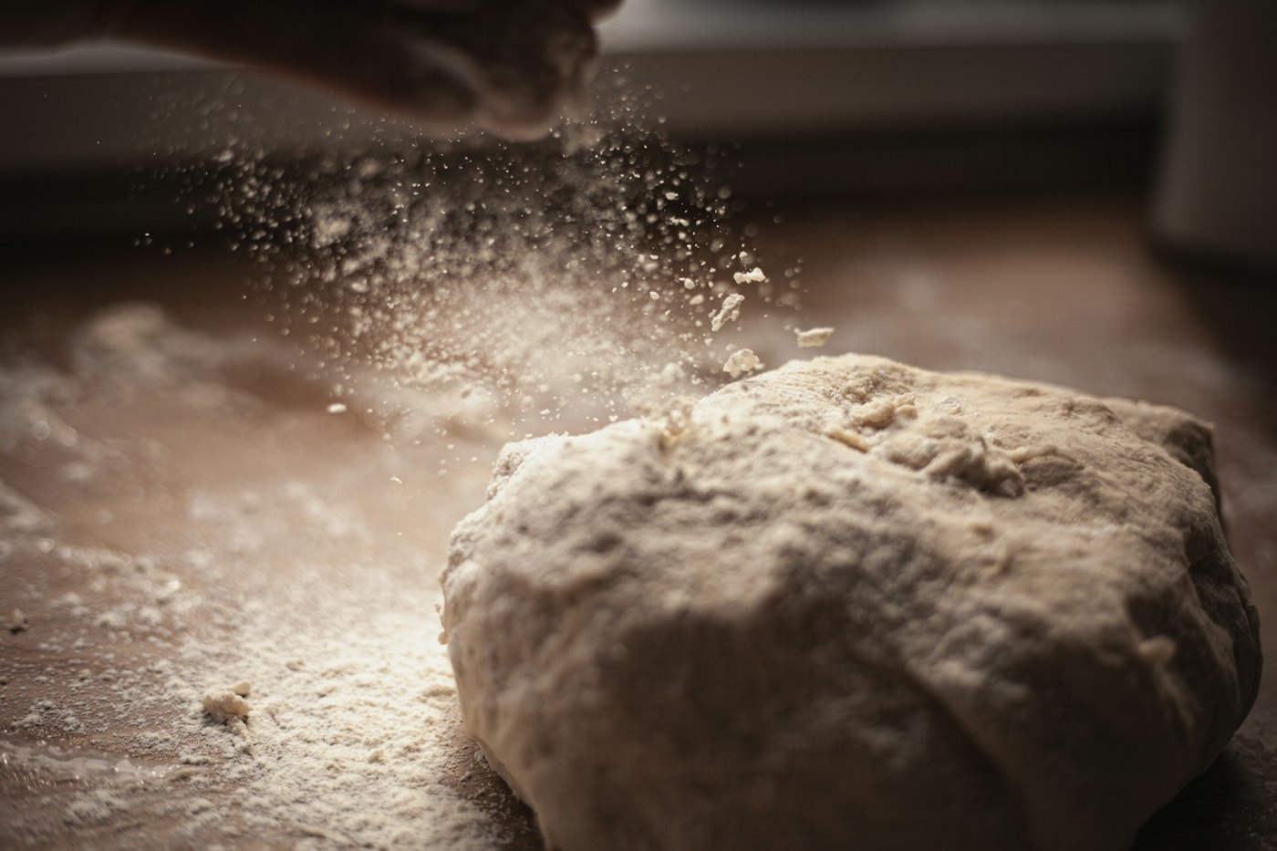 Baker kneading dough on a wooden board
