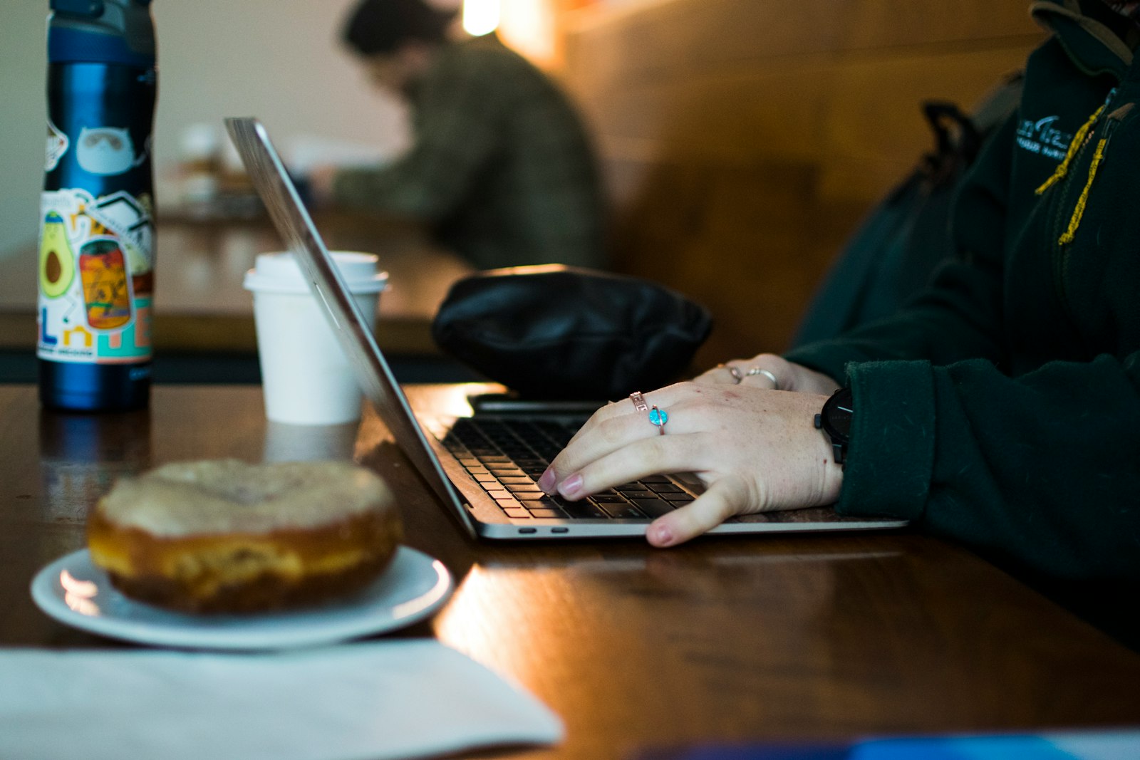 A person using a laptop on a wooden table
