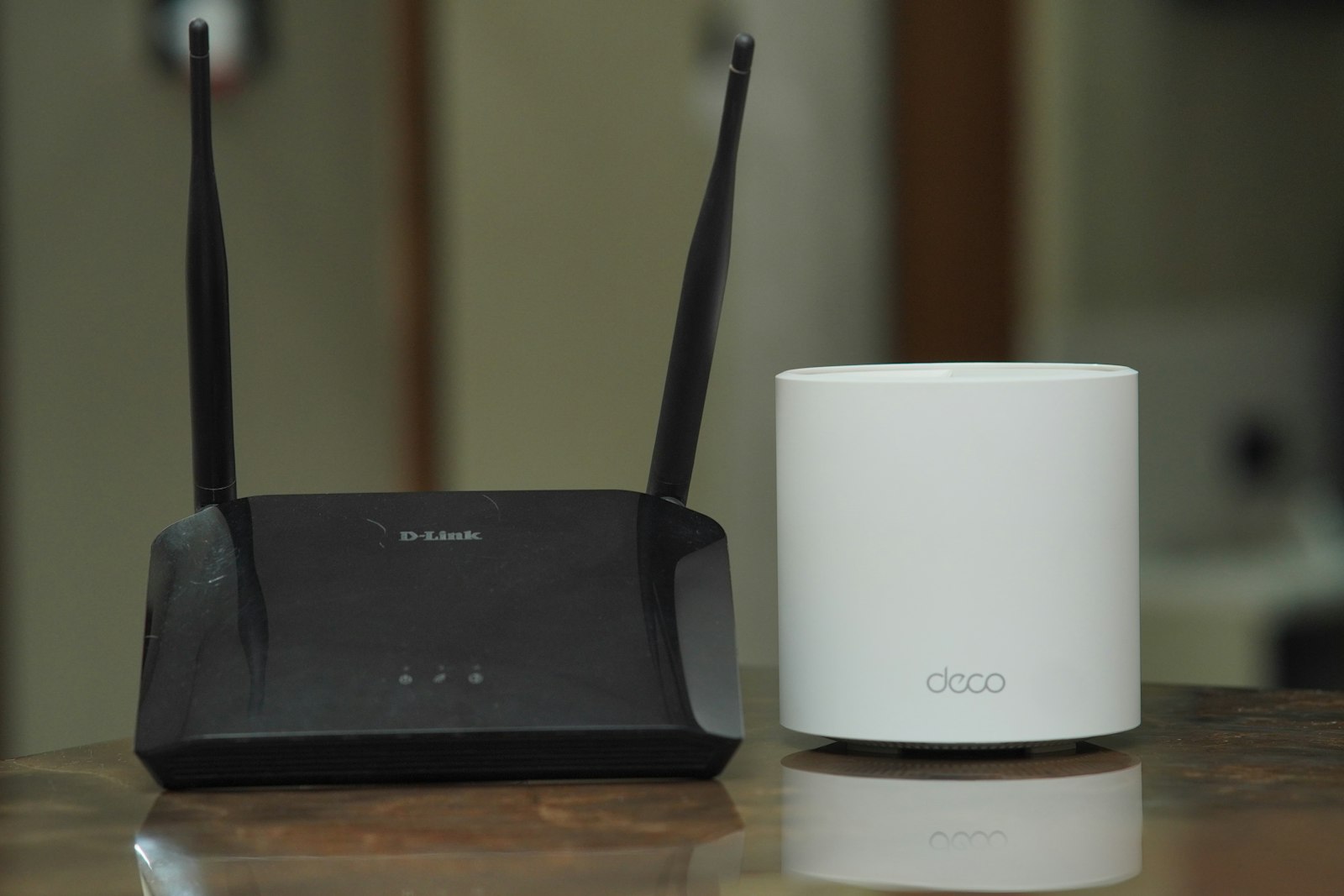A traditional Wi-Fi router beside a TP-Link Deco X20 mesh unit for comparison