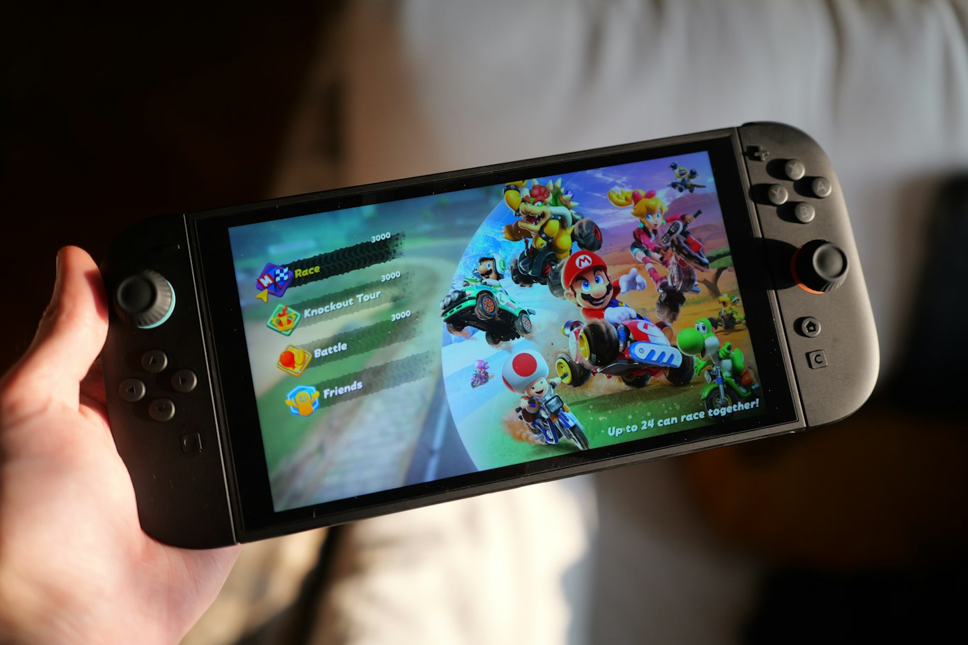 Person playing Mario Kart on a Nintendo Switch handheld