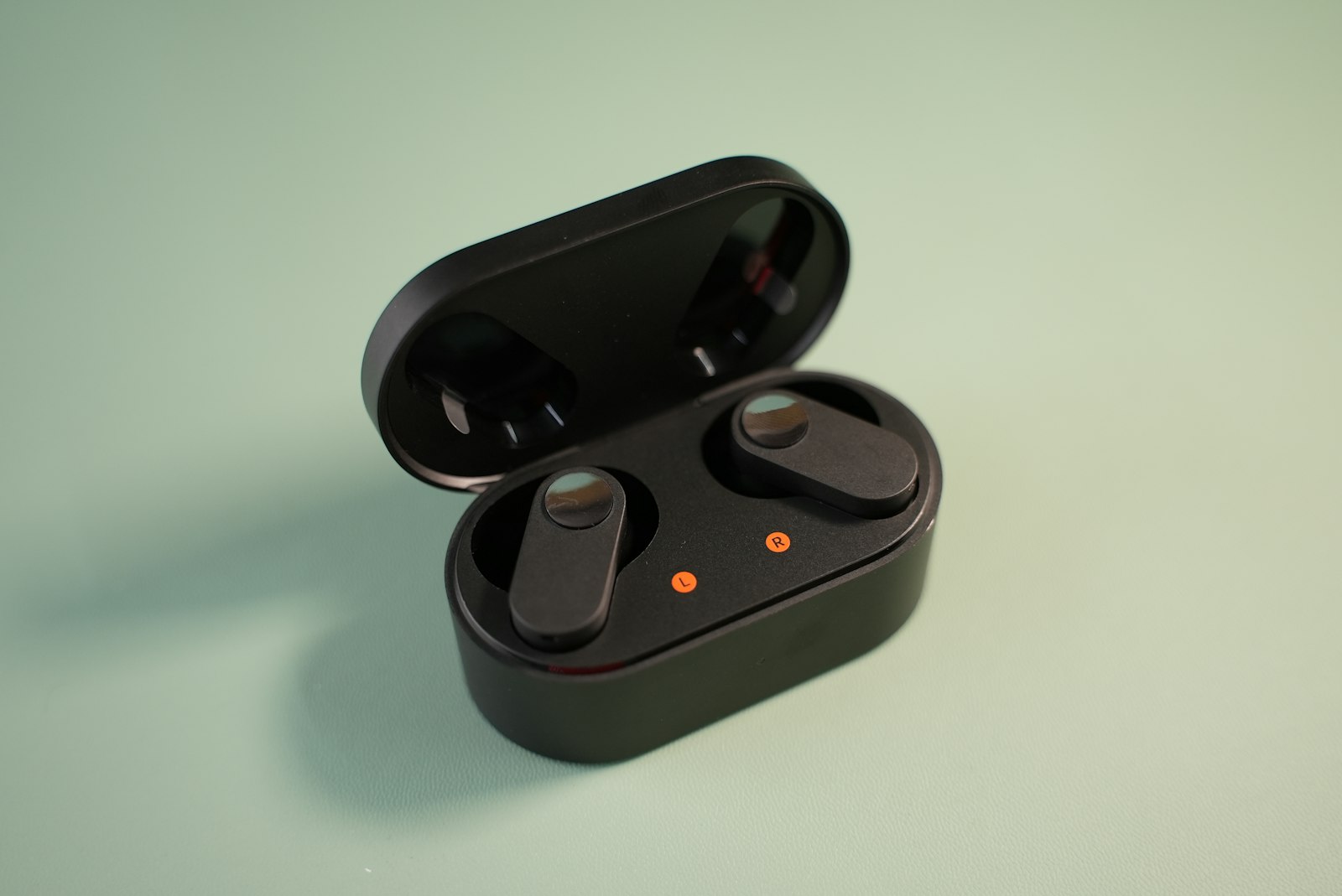 Wireless earbuds and a charging case on a table