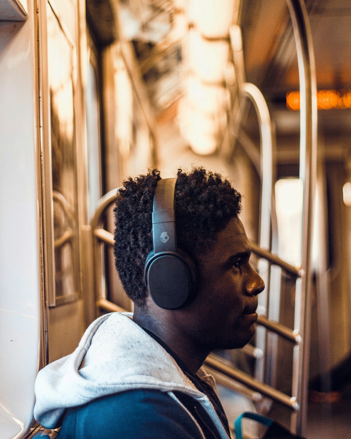Commuter wearing wireless over-ear headphones on a transit car