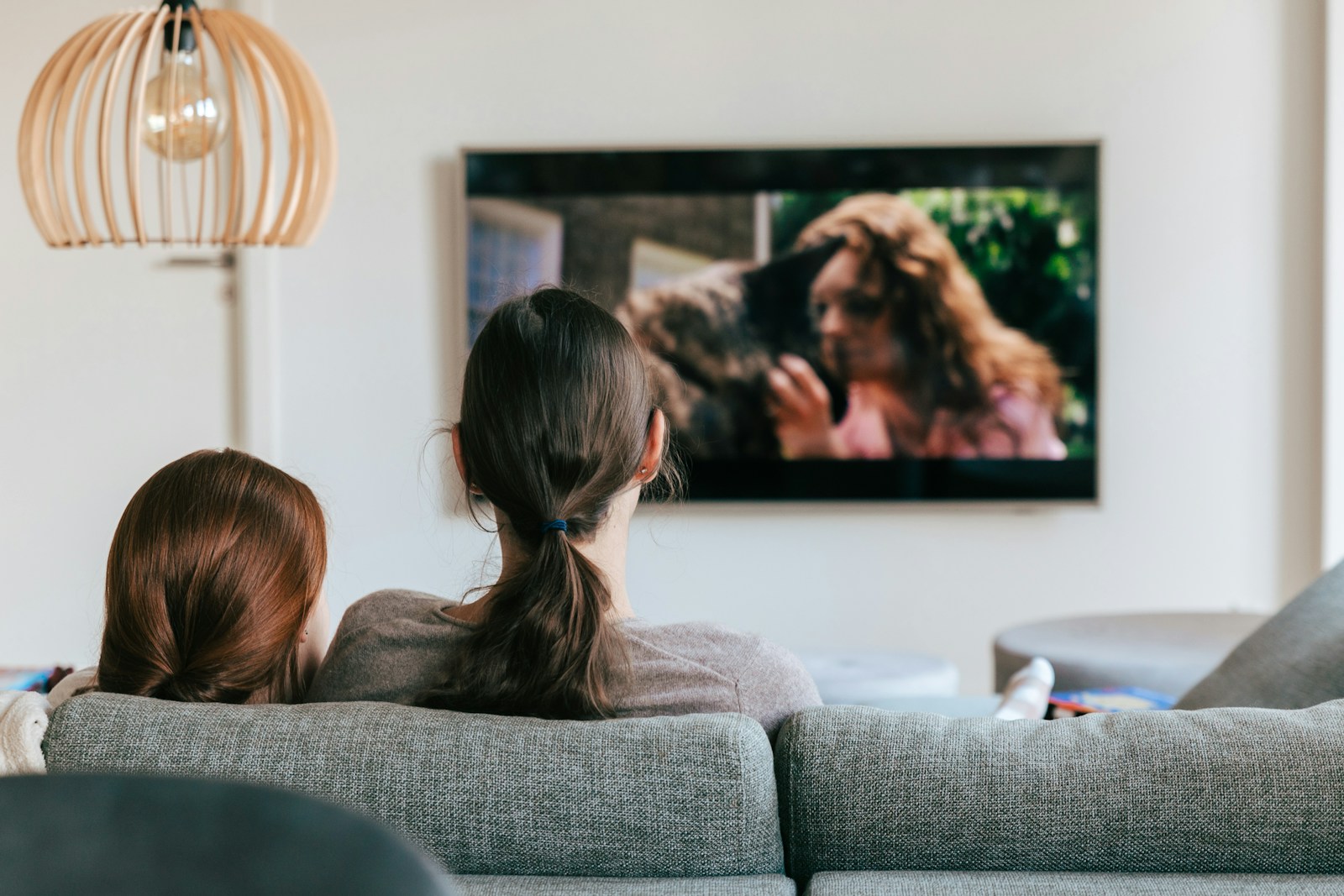 People watching a movie together on a couch in front of a television