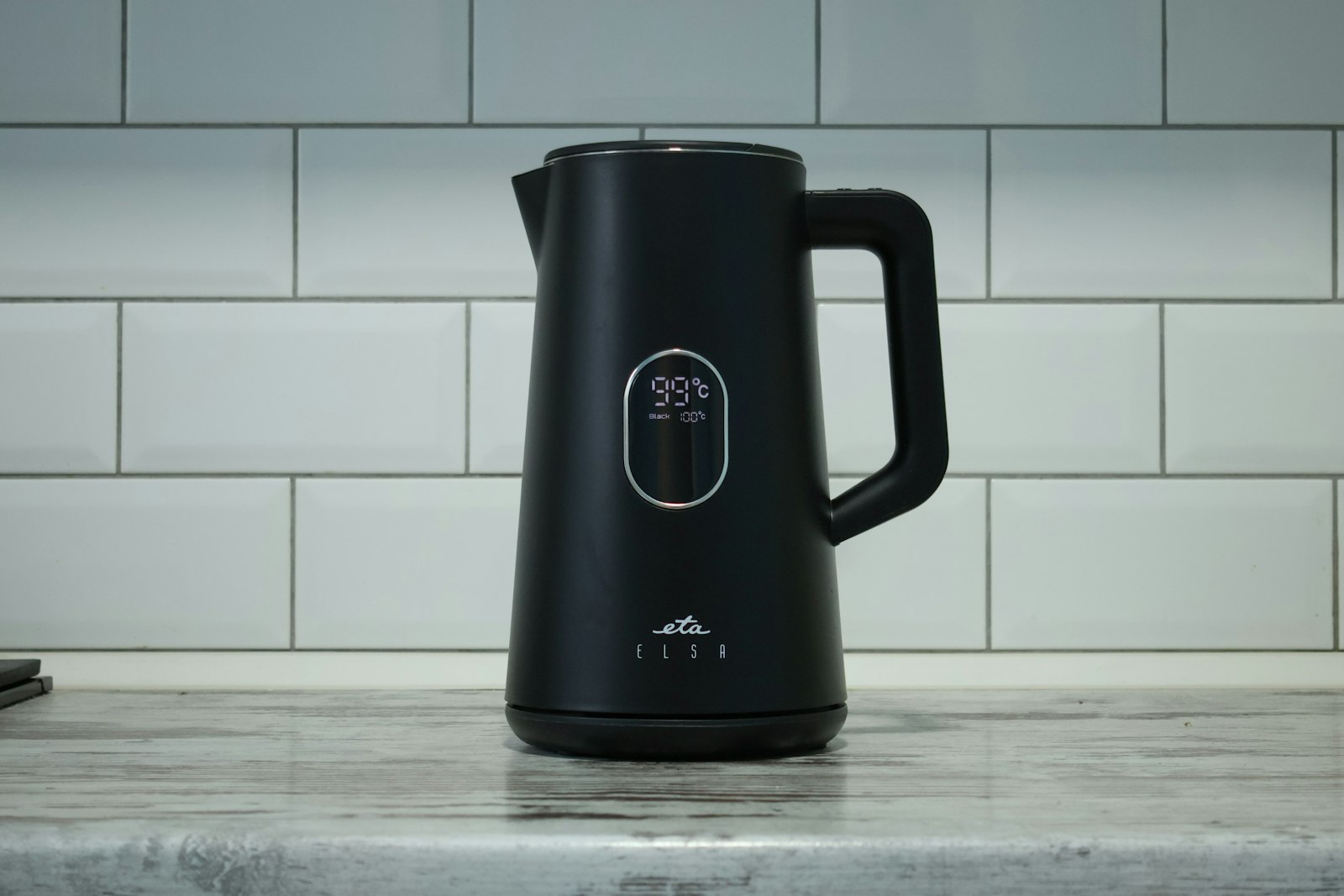 Black electric kettle with a digital temperature display on a kitchen counter