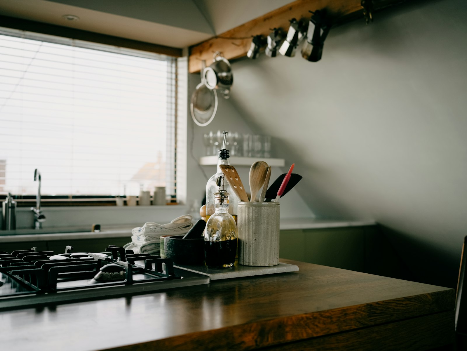 Kitchen counter with a crock of cooking utensils beside a gas stove