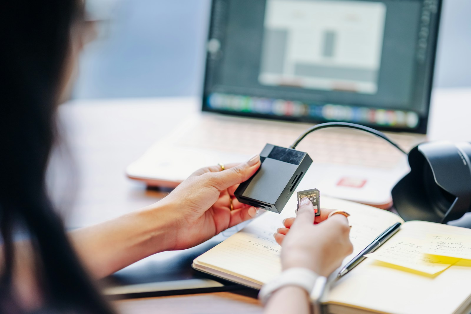 Person connecting an external drive to a card reader to copy photos