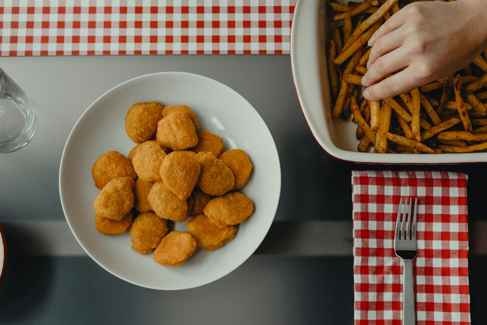 Overhead view of nuggets on a plate with a tray of fries