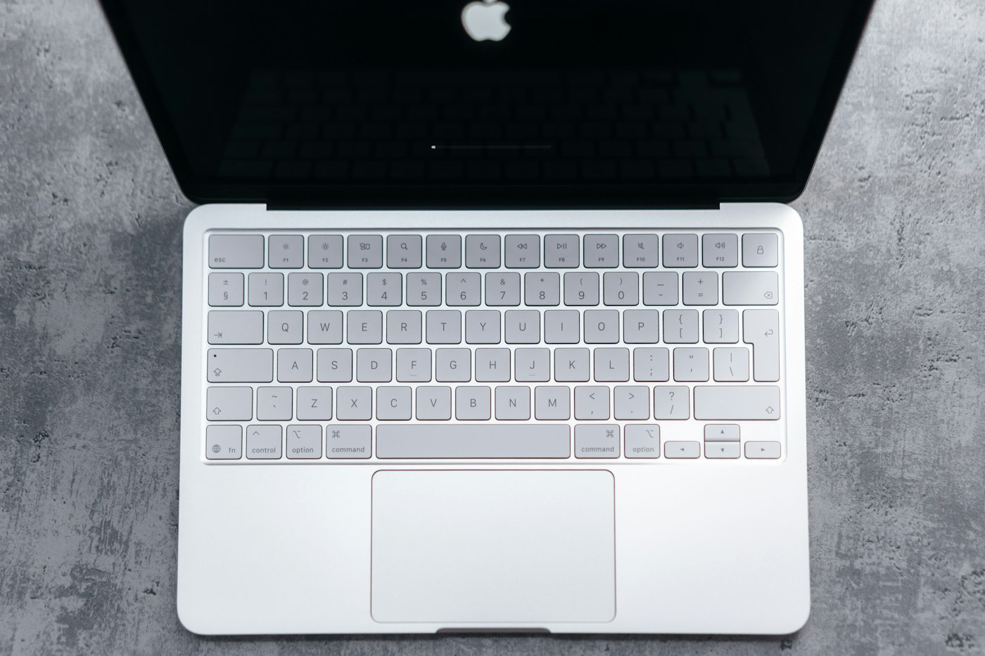 Silver laptop keyboard and trackpad seen from above