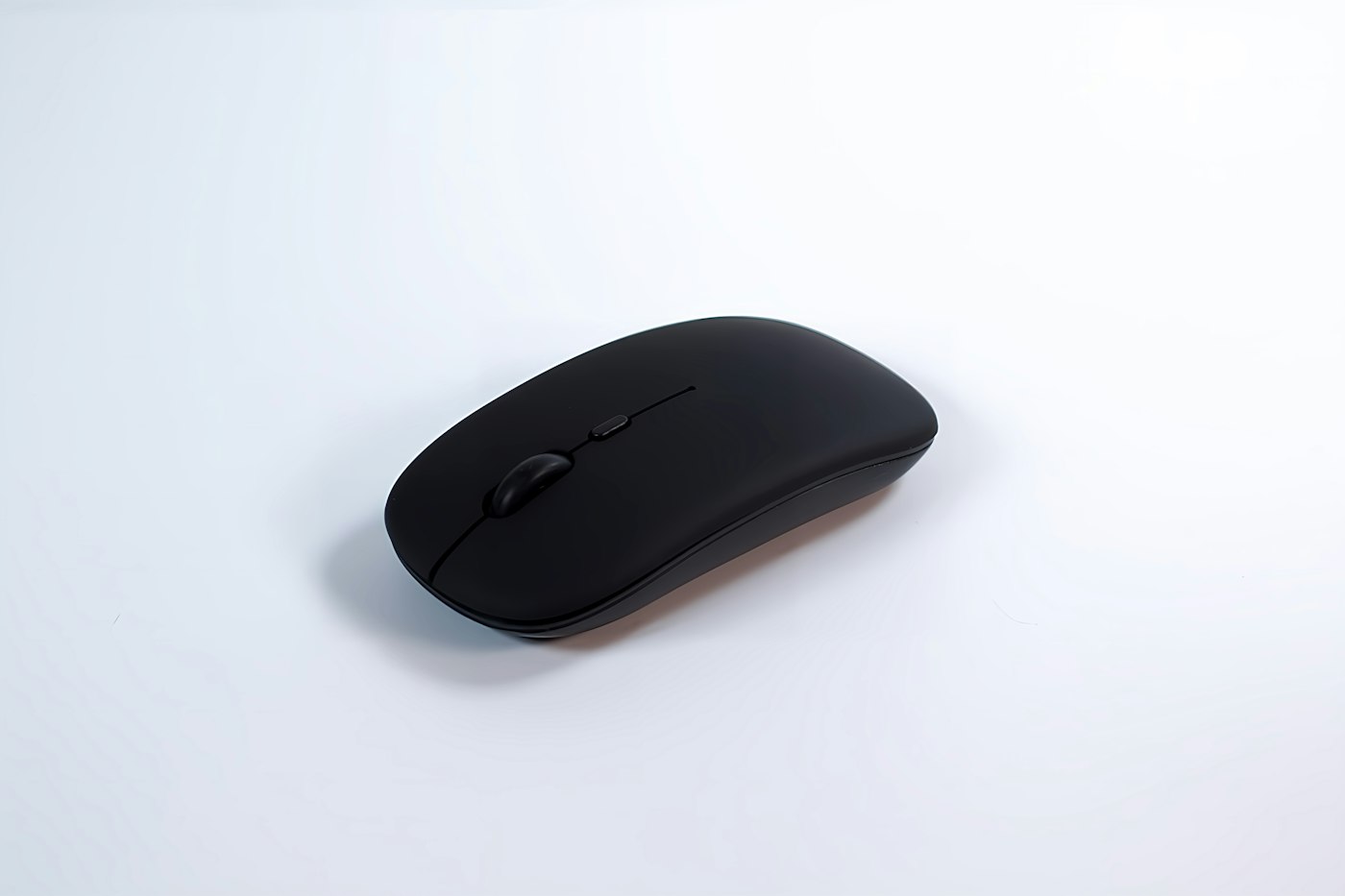 Slim black wireless mouse on a light surface