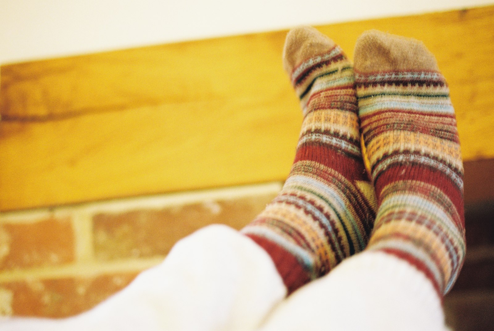 Striped wool socks propped against a brick wall