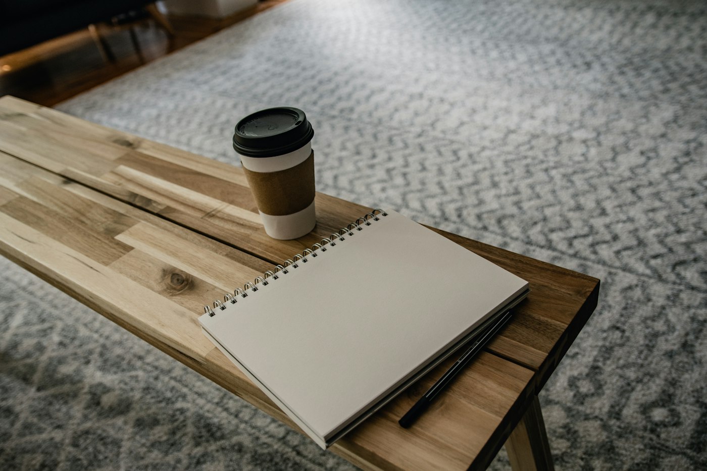 Blank notebook and coffee on a wooden bench, a classic gift pairing for a teacher