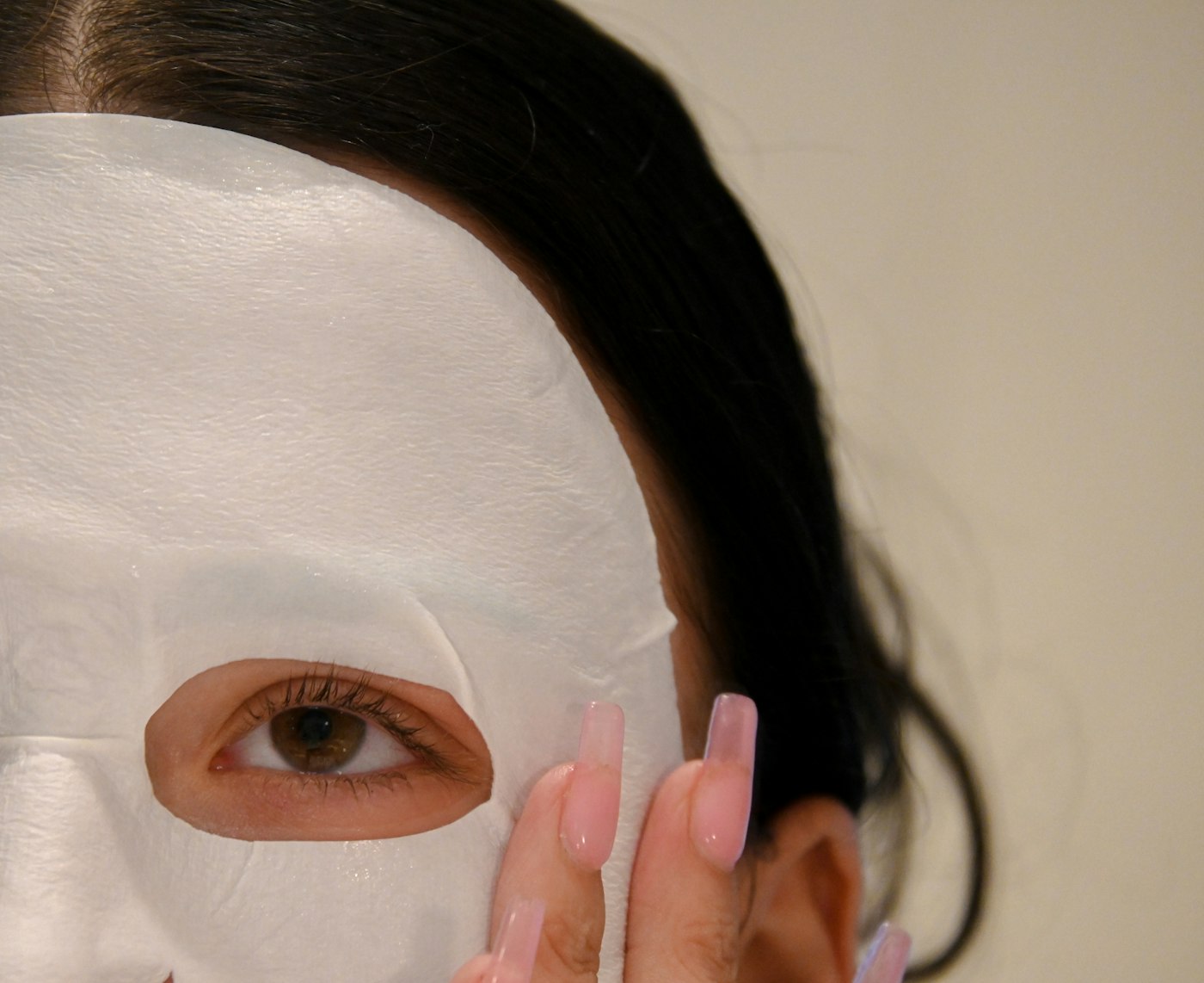 Woman wearing a white face mask during a skincare routine